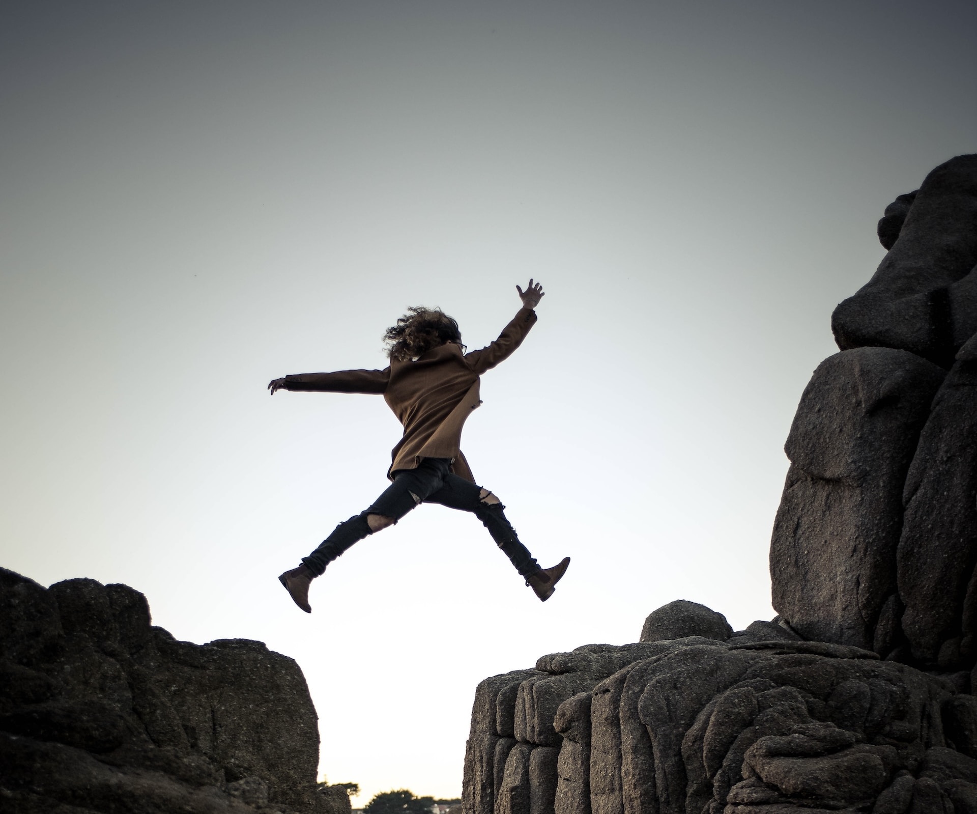 Woman jumping over a ravine